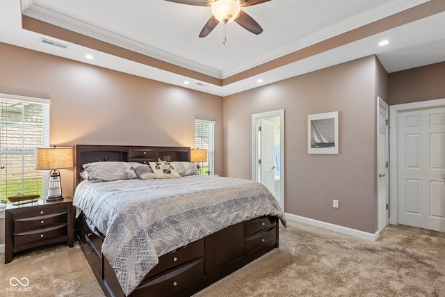 bedroom with a tray ceiling, multiple windows, light colored carpet, and ceiling fan