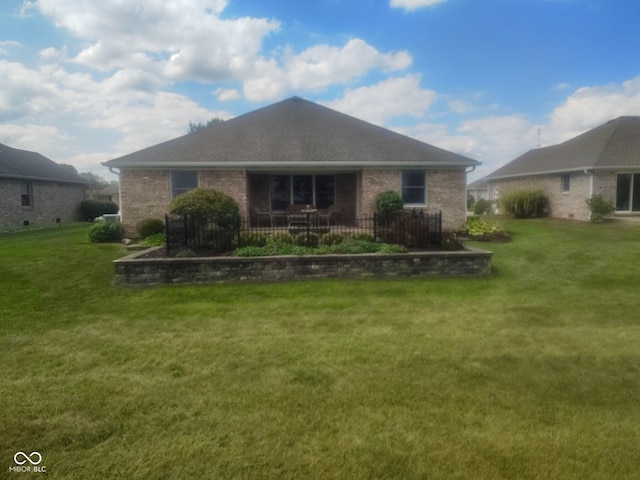 rear view of property with a yard