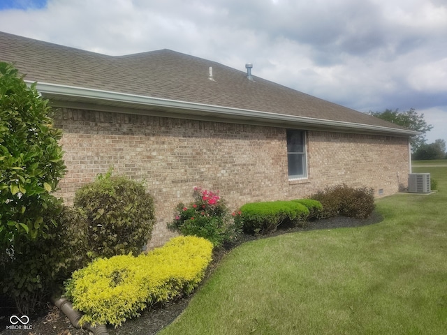 view of side of home featuring a yard and central AC unit