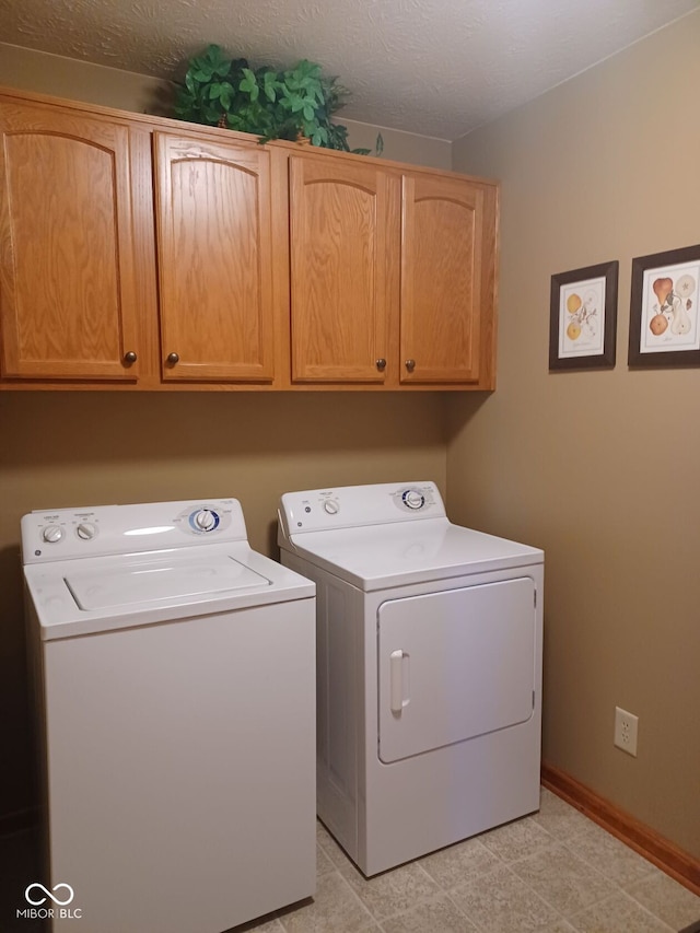 clothes washing area featuring independent washer and dryer, light tile patterned flooring, a textured ceiling, and cabinets