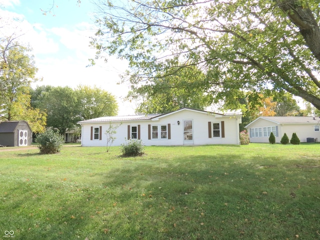 back of house featuring a shed and a lawn