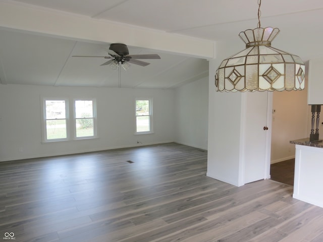 spare room with vaulted ceiling with beams, a healthy amount of sunlight, hardwood / wood-style flooring, and ceiling fan