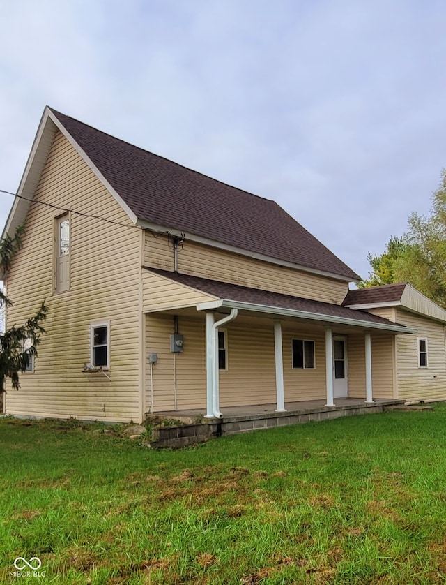 rear view of property featuring a lawn