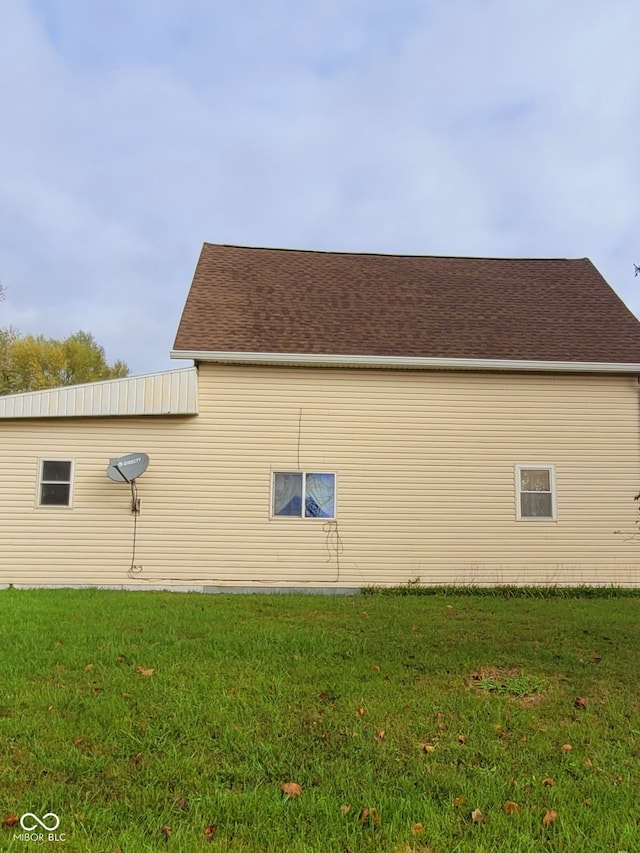 view of side of home with a yard