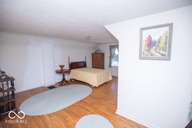 bedroom featuring hardwood / wood-style flooring and lofted ceiling