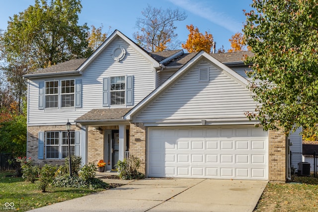 front of property with central AC unit and a garage