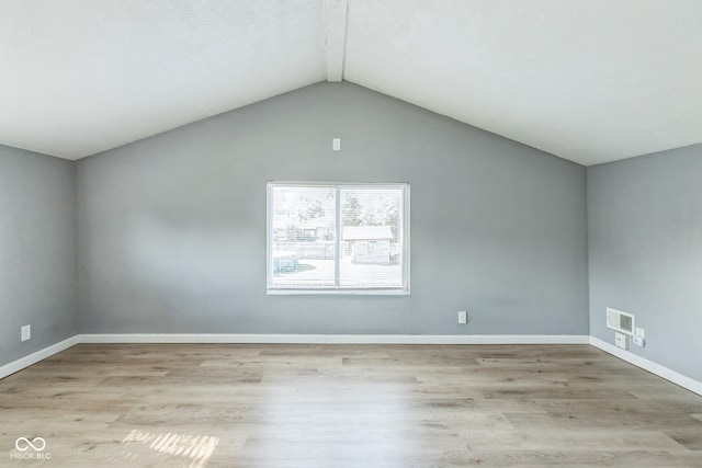 unfurnished room with light wood-type flooring and vaulted ceiling