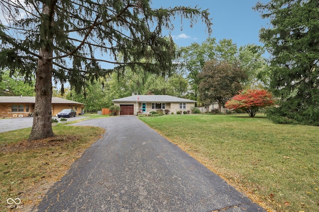 single story home featuring a front lawn and a garage