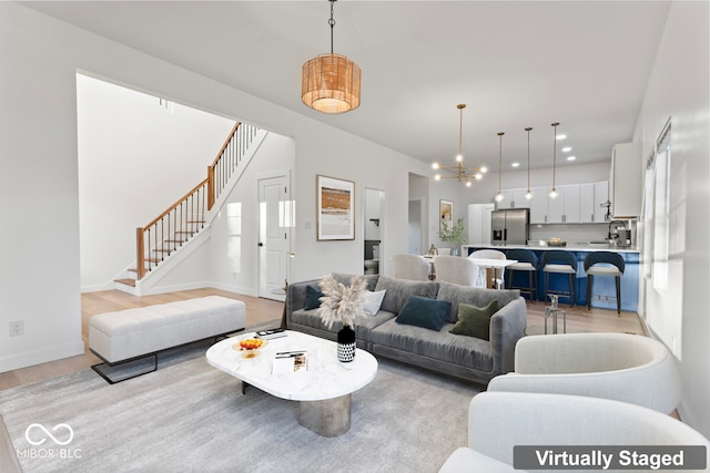 living room featuring a notable chandelier and light hardwood / wood-style floors