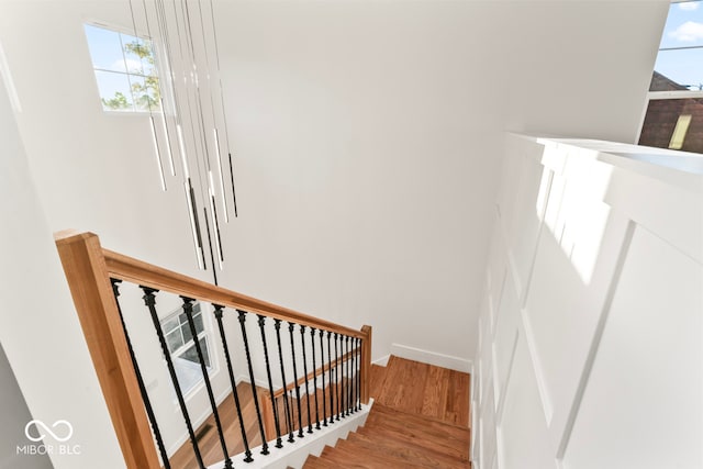 stairway featuring a wealth of natural light and hardwood / wood-style flooring