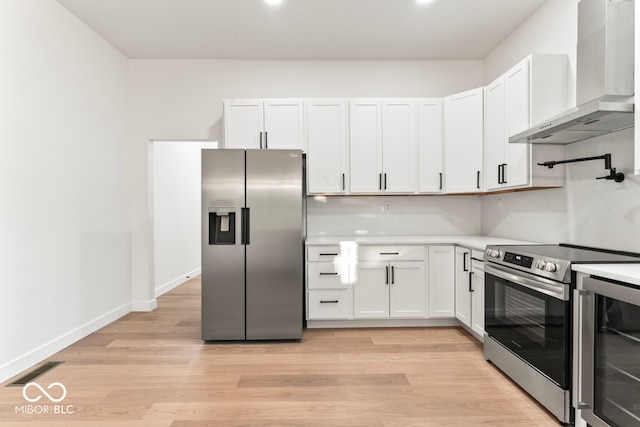 kitchen with wall chimney range hood, light wood-type flooring, stainless steel appliances, white cabinets, and wine cooler