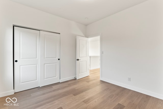 unfurnished bedroom with a closet and light hardwood / wood-style flooring