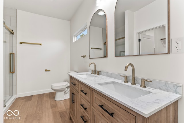 bathroom featuring vanity, wood-type flooring, toilet, and walk in shower