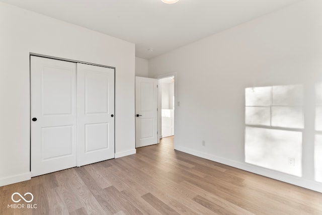 unfurnished bedroom with a closet and light hardwood / wood-style flooring