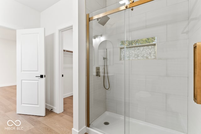 bathroom with hardwood / wood-style floors and a shower with shower door