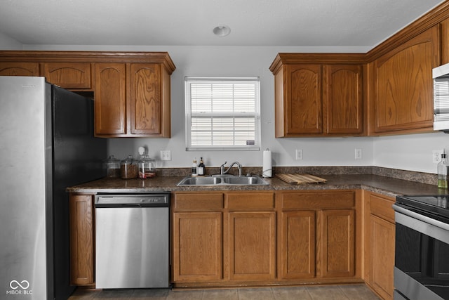 kitchen featuring light tile patterned flooring, appliances with stainless steel finishes, sink, and a textured ceiling