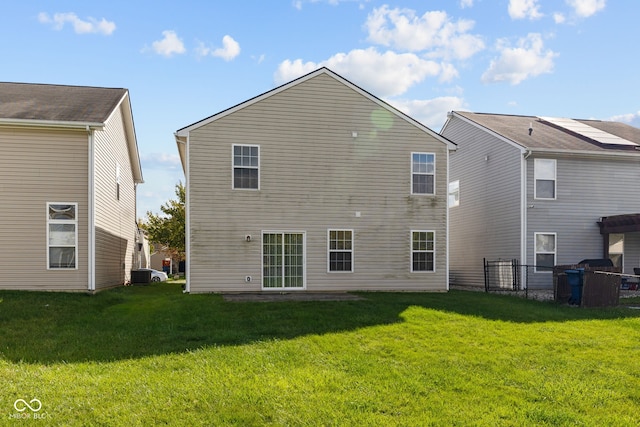 back of house featuring a yard and cooling unit