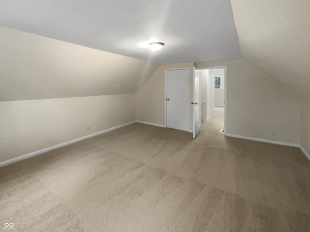 additional living space with carpet floors and vaulted ceiling