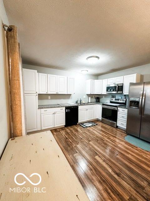 kitchen featuring white cabinets, stainless steel appliances, and dark hardwood / wood-style flooring