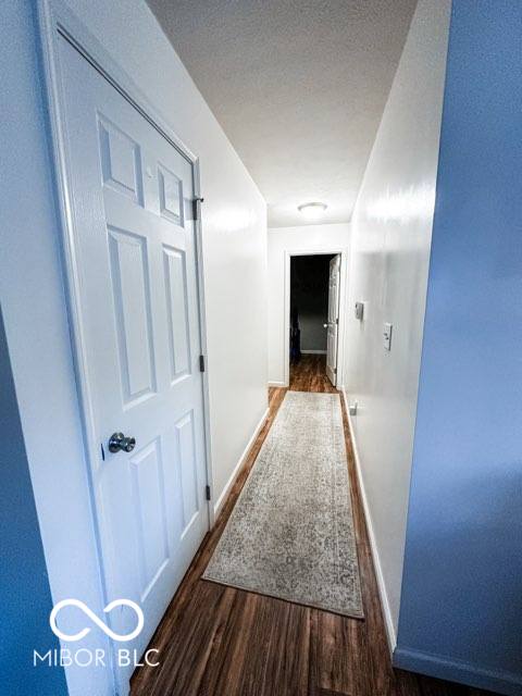 hallway featuring dark hardwood / wood-style floors and a textured ceiling