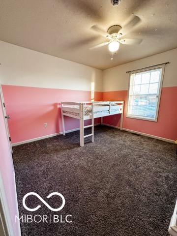 unfurnished bedroom featuring dark colored carpet and ceiling fan