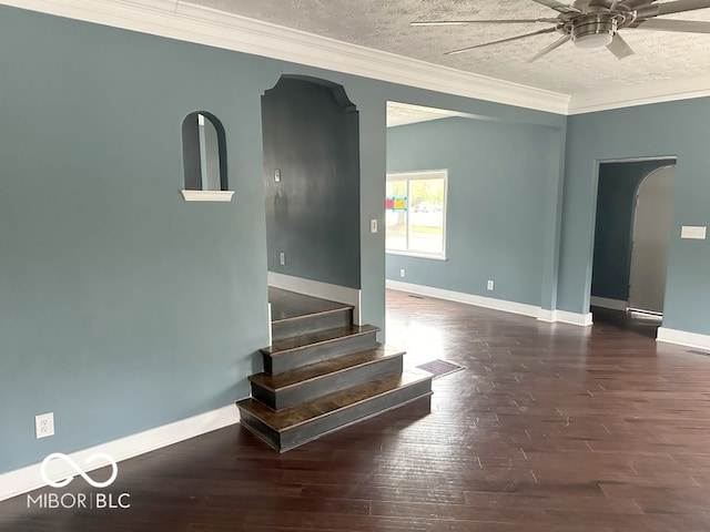 interior space with ornamental molding, a textured ceiling, ceiling fan, and dark hardwood / wood-style flooring