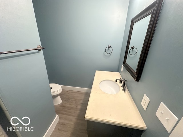 bathroom featuring vanity, wood-type flooring, and toilet