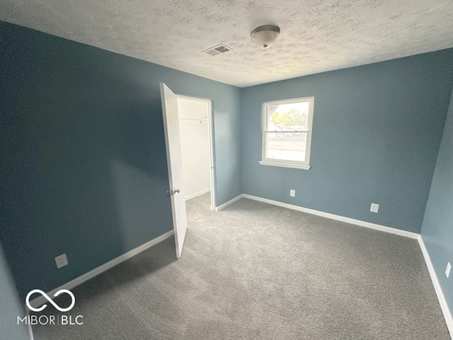 carpeted spare room featuring a textured ceiling