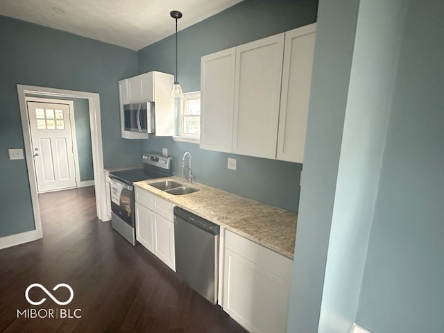 kitchen featuring white cabinets, dark hardwood / wood-style flooring, appliances with stainless steel finishes, pendant lighting, and sink