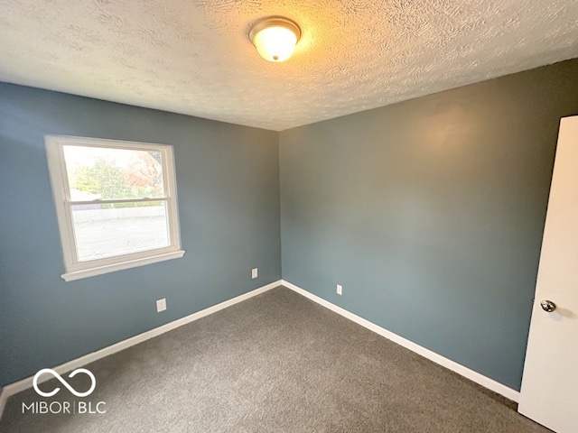 carpeted empty room with a textured ceiling