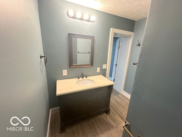 bathroom with vanity, a textured ceiling, and hardwood / wood-style flooring