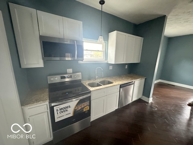 kitchen featuring appliances with stainless steel finishes, white cabinets, sink, and dark wood-type flooring