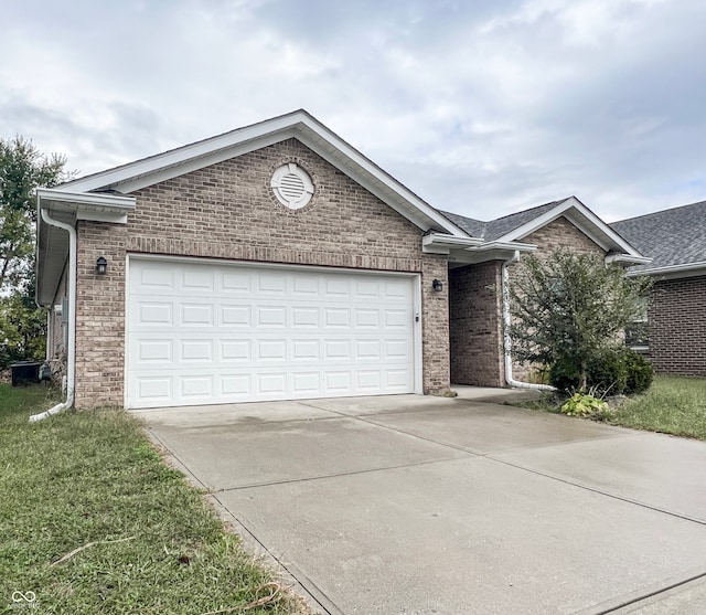 single story home with a garage and a front lawn