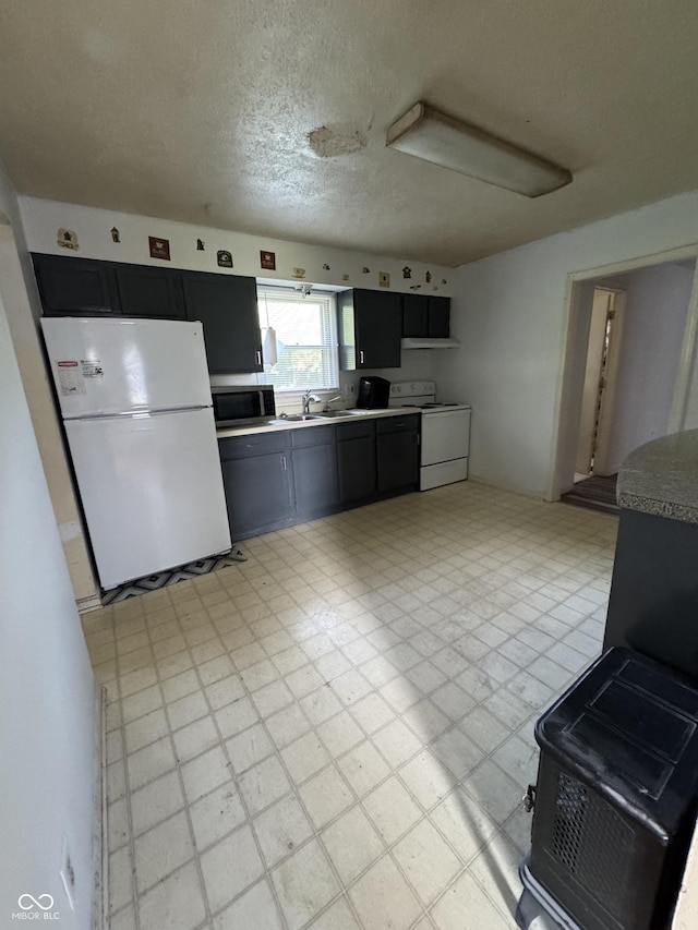 3231 W State Road 32, Westfield, IN 46074 - kitchen featuring white appliances, light floors, a textured ceiling, and dark cabinetry