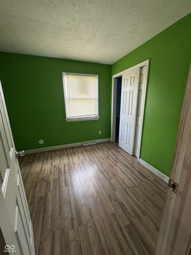 3231 W State Road 32, Westfield, IN 46074 - unfurnished bedroom featuring wood finished floors, a textured ceiling, and a closet