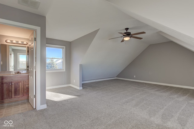 additional living space with sink, ceiling fan, lofted ceiling, and light colored carpet