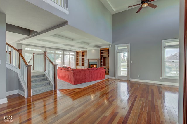 7189 Lockford N, Avon, IN 46123 - living room with wood-type flooring, stairway, a warm lit fireplace, ceiling fan, and baseboards