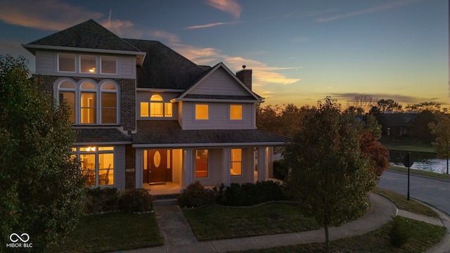7189 Lockford N, Avon, IN 46123 - view of front facade featuring a chimney, covered porch, a yard, and brick siding