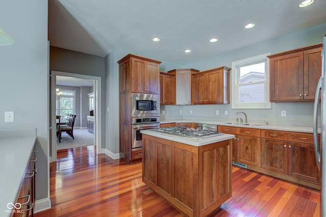 kitchen with dark hardwood / wood-style flooring, stainless steel appliances, sink, and a kitchen island