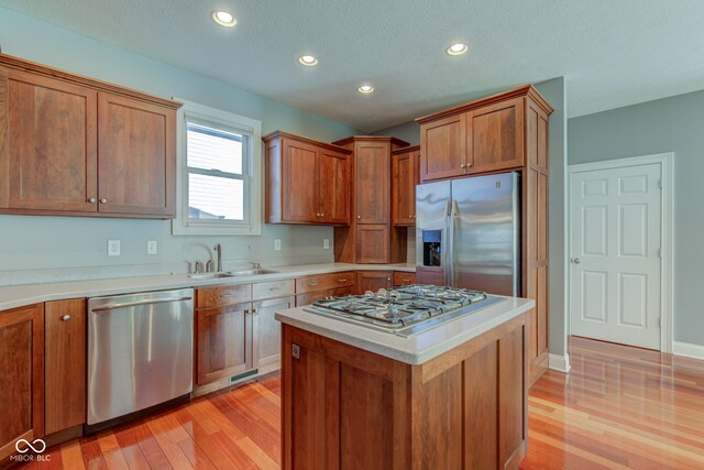 7189 Lockford N, Avon, IN 46123 - kitchen featuring stainless steel appliances, a sink, light wood finished floors, brown cabinetry, and light countertops