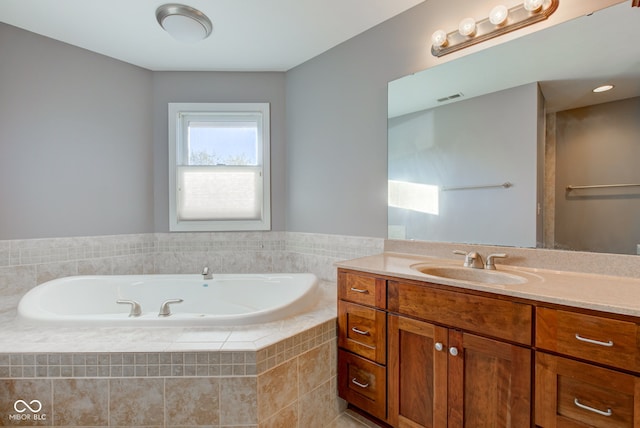 bathroom with vanity and a relaxing tiled tub