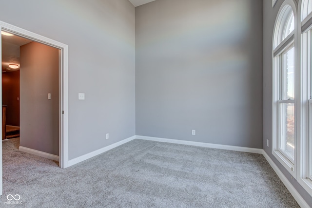 spare room featuring light carpet and a healthy amount of sunlight