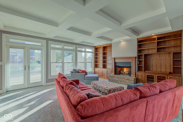 carpeted living room with french doors, coffered ceiling, plenty of natural light, and a brick fireplace