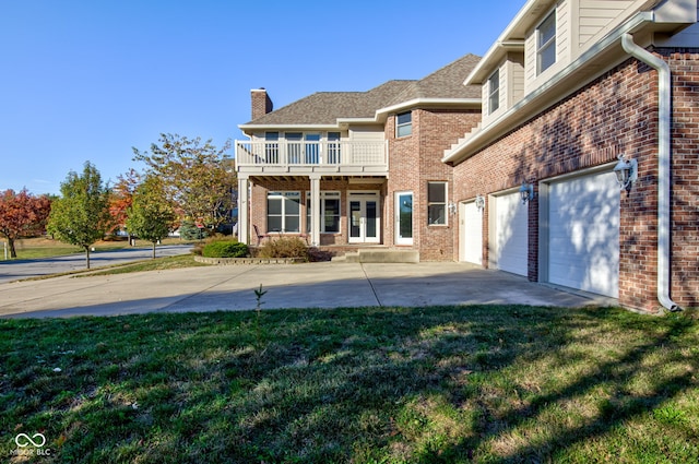 7189 Lockford N, Avon, IN 46123 - rear view of property featuring a chimney, a yard, concrete driveway, brick siding, and a balcony