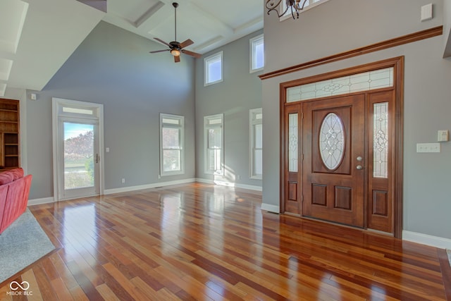 foyer entrance featuring beam ceiling, coffered ceiling, hardwood / wood-style flooring, and ceiling fan