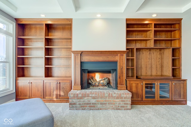 carpeted living room featuring built in shelves, a fireplace, and a wealth of natural light