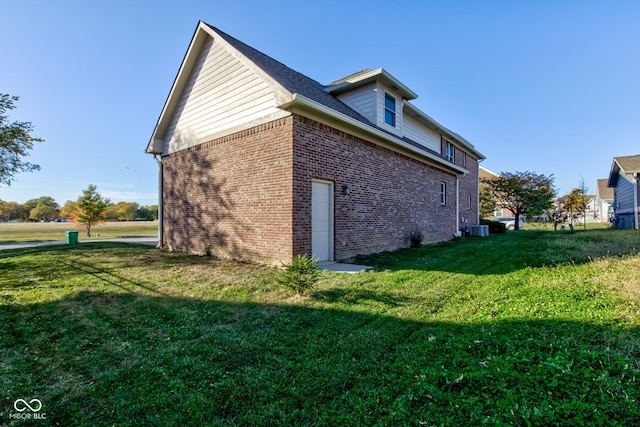 view of side of property featuring a lawn and central AC unit