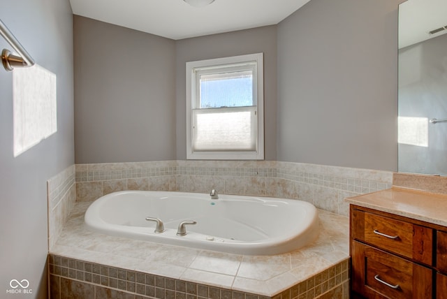 bathroom with vanity and tiled tub