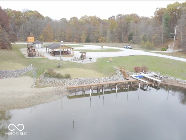 view of property's community with a water view and a lawn