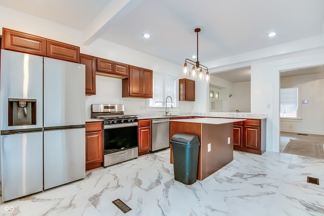 kitchen with beam ceiling, stainless steel appliances, sink, pendant lighting, and a center island